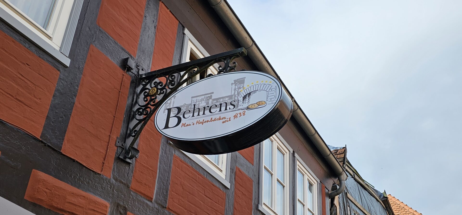 Schild „Plau's Hafenbäcker' am Fachwerk der Bäckerei Behrens